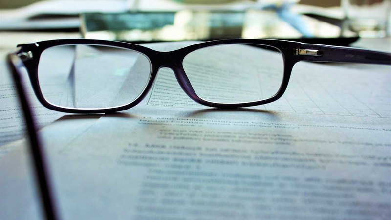 closeup of a pair of glasses on top of an assault lawyer's desk