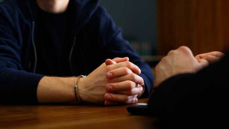 felony attorney sitting at the desk and having a discussion with a client. closeup of their hands